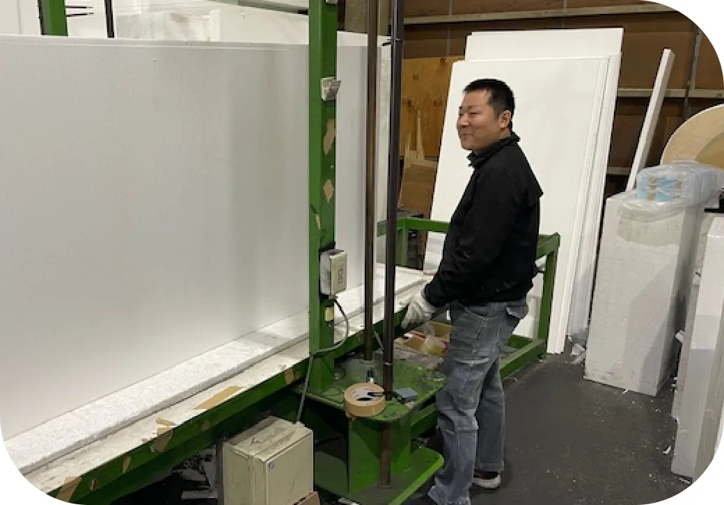 工場内で機械を操作し材料加工を行うスタッフ